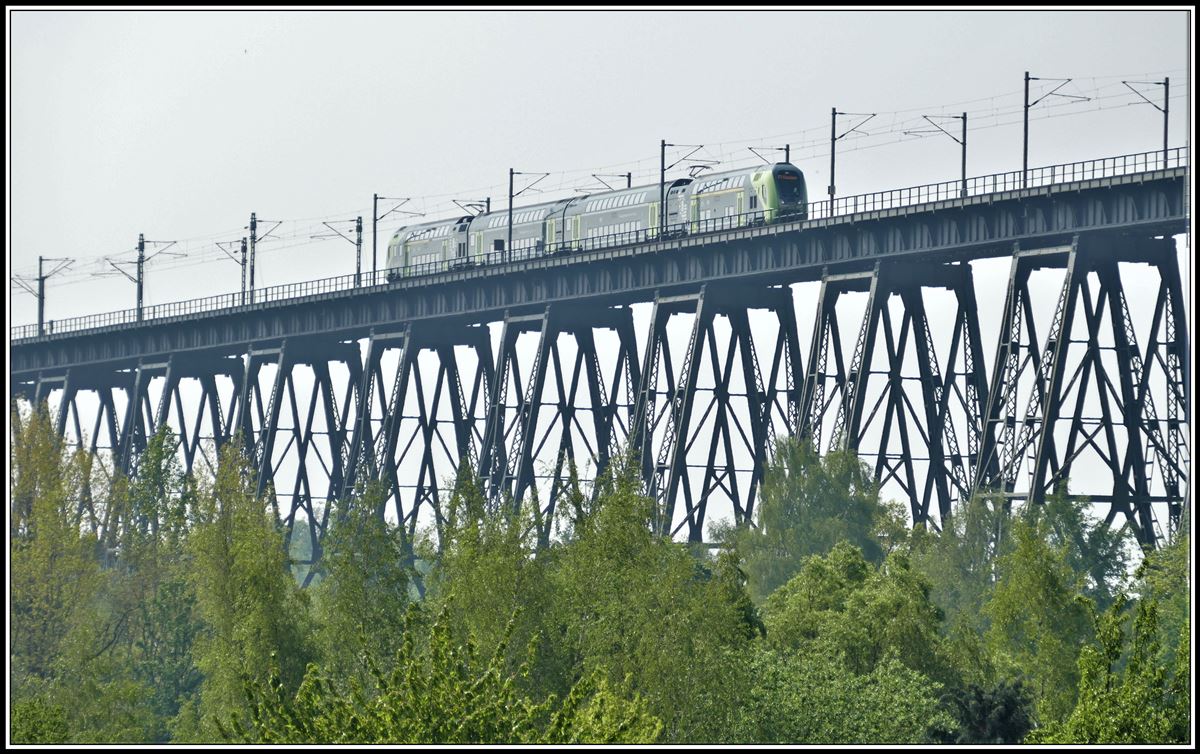 RE21060 aus Hamburg mit einer Doppelstockgarnitur BR445 nähert sich dem Mittelteil der 2170m langen Rendsburger Hochbrücke über den Nord-Ostsee-Kanal.Aufnahmeort Sundawitter Weg. (18.05.2019)