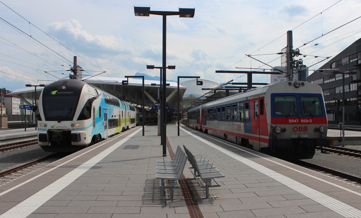 Rechts fahren 5047 063-2 und 5047 071-5 am 26.06.2015 als REX 5821 (Salzburg Taxham Europapark - Branau/Inn) aus Salzburg Hbf, während links 4010 001 von der Wetsbahn immer noch auf die Abfahrt um 15:52 als WB 925 (Salzburg Hbf - Wien Westbahnhof) wartet.