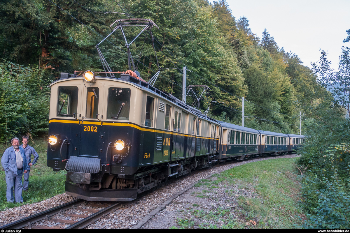 Reconstitution du Golden Mountain Pullman Express: Am 8. September 2017 wurde zu einer speziellen Fotofahrt eingeladen. Der FZe 6/6 2002 der Chemin de fer-musée Blonay-Chamby sollte mit den GoldenPass Classic Wagen der MOB zusammengebracht werden und so den legendären Golden Mountain Pullman Express aus den Jahren 1931/32 nachstellen, welchem aufgrund der Weltwirtschaftskrise leider kein Erfolg beschieden war. Da die Wagen in nächster Zeit auf die neue automatische Kupplung umgebaut werden, war dies die letzte Gelgegenheit für ein solches Zusammentreffen.<br>
Da der FZe 6/6 2002 aufgrund seines Zustands derzeit nicht für lange Fahrten gebraucht werden kann und weil die Wagen tagsüber im Einsatz stehen, wurde am Freitagabend eine kurze Fahrt von Sendy-Sollard nach Chamby durchgeführt. Die Wagen wurden vorher mit den Fotografen von der GDe 4/4 6001 von Montreux nach Sendy-Sollard gebracht (wobei die Fotografen kurz vorher an der Fotostelle ausgeladen wurden) und am Ende in Chamby wieder abgeholt für die Rückfahrt nach Montreux.<br>
Der Fotozug am Bahnübergang zwischen Sendy-Sollard und Chamby.