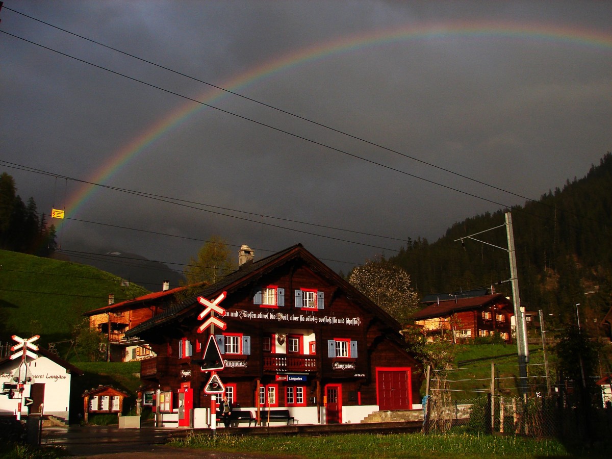 Regenbogen über dem Bahnhofsgebäude Langwies.
Es war eine tolle Erfahrung zu sehen und erleben das Phänomen der Licht.
Es war nur ein paar Minuten....
Strecke Arosabahn (Chur - Arosa) 10.05.2014.