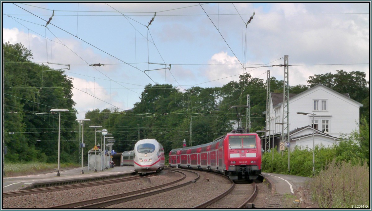 Reger Bahnverkehr am Bahnhof von Eschweiler (Rhl),am 30.Juli.2014.
Während der NRW Express aud das Abfahrtssignal wartet,legt sich der ICE 3 aus Brüssel elegant in den Gleisbogen.