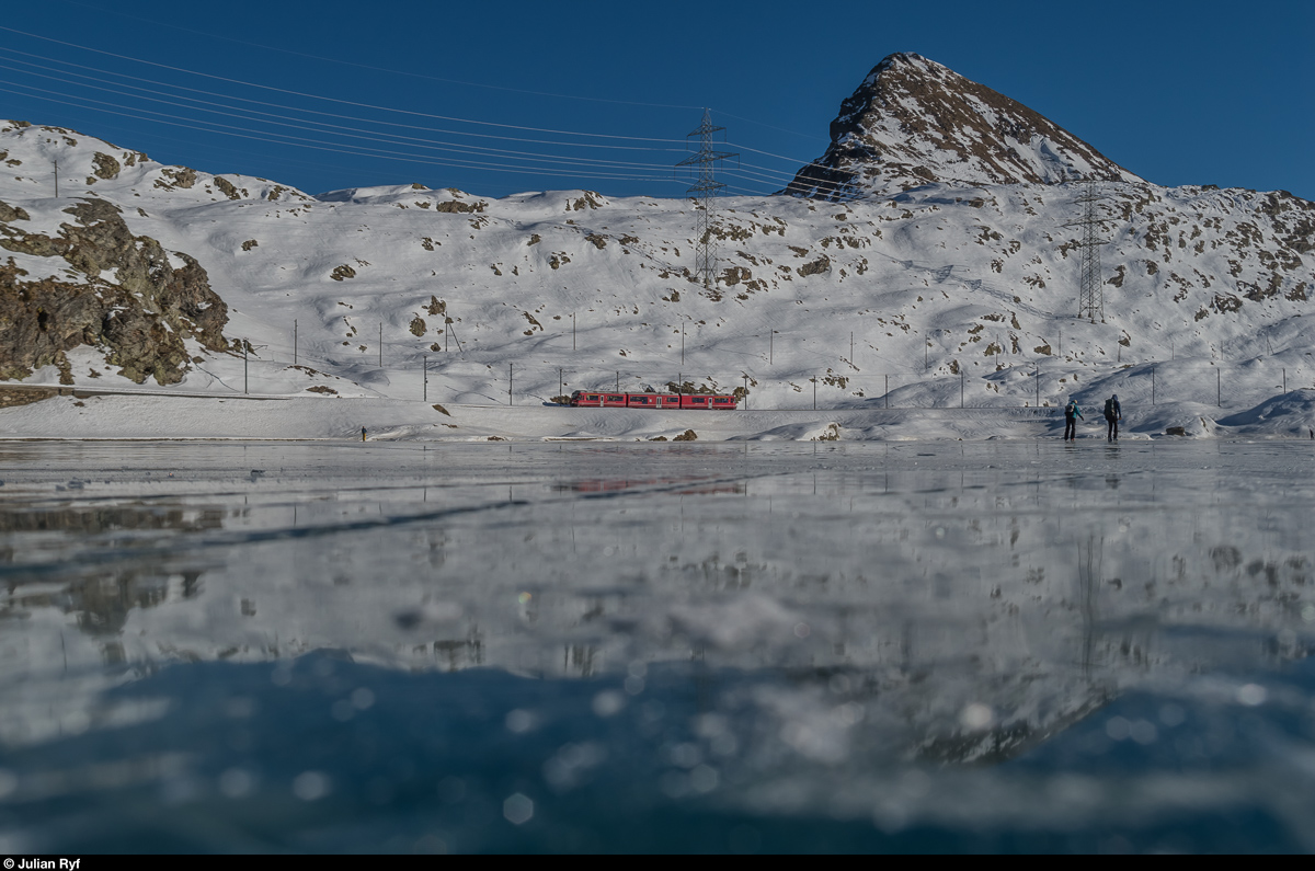 Regio 1648 Poschiavo - St. Moritz wird am 29. Dezember 2016 von einem Allegra als Alleinfahrer geführt. Hier befindet sich der Regionalzug vor der Kulisse des Piz Campasc am gefrorenen Lago Bianco.