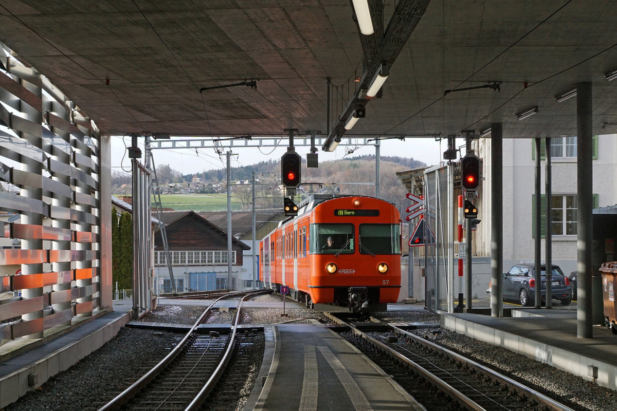Regionalverkehr Bern Solothurn/RBS.
Einfahrt in den Endbahnhof Worb-Dorf.
MANDARINLI  ADIEU.
Nach 45 Dienstjahren haben die bekannten Mandarinli, wie sie im Volksmund heissen ausgedient.
Während diesen vielen Jahren prägten sie das Bild sehr stark im Worblental auf der S 7 Bern – Worb Dorf. In der Woche vom  11. Bis zum 15. Dezember 2019 standen sie ein letztes Mal im Plandienst, damit sich die Fahrgäste und die Eisenbahnfreunde von ihnen verabschieden konnten.  Die beiden letzten Triebzüge Be 4/12 56 und Be 4/12 57 werden zwar vorerst nicht verschrottet, da sie noch als eiserne Reserve zurückbehalten werden. Da ich zusammen mit diesen eleganten orangen Triebzügen  den grössten Teil  meines Lebens verbringen  konnte, freue ich mich über sehr viele Abschiedsbilder unter BB.de.  Ich werde meinen Beitrag leisten. Ich verabschiedete mich am Freitag den 13. Dezember 2019 zusammmen mit mehreren Bahnfreunden.  
So himmeltraurig das Wetter, so traurig der Abschied von diesem Zug.  Nicht nur das Taschentuch sondern auch meine Kleider waren durch und durch nass.
Mandarinli adieu!
Foto: Walter Ruetsch
