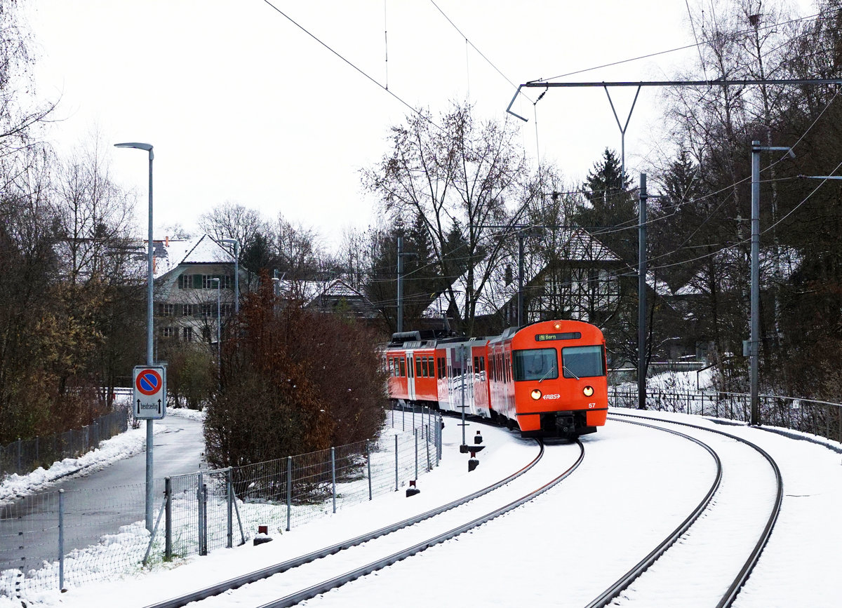Regionalverkehr Bern Solothurn/RBS.
Einfahrt Papiermühle.
MANDARINLI  ADIEU.
Nach 45 Dienstjahren haben die bekannten Mandarinli, wie sie im Volksmund heissen ausgedient.
Während diesen vielen Jahren prägten sie das Bild sehr stark im Worblental auf der S 7 Bern – Worb Dorf. In der Woche vom  11. Bis zum 15. Dezember 2019 standen sie ein letztes Mal im Plandienst, damit sich die Fahrgäste und die Eisenbahnfreunde von ihnen verabschieden konnten.  Die beiden letzten Triebzüge Be 4/12 56 und Be 4/12 57 werden zwar vorerst nicht verschrottet, da sie noch als eiserne Reserve zurückbehalten werden. Da ich zusammen mit diesen eleganten orangen Triebzügen  den grössten Teil  meines Lebens verbringen  konnte, freue ich mich über sehr viele Abschiedsbilder unter BB.de.  Ich werde meinen Beitrag leisten. Ich verabschiedete mich am Freitag den 13. Dezember 2019 zusammmen mit mehreren Bahnfreunden.  
So himmeltraurig das Wetter, so traurig der Abschied von diesem Zug.  Nicht nur das Taschentuch sondern auch meine Kleider waren durch und durch nass.
Mandarinli adieu!
Foto: Walter Ruetsch
