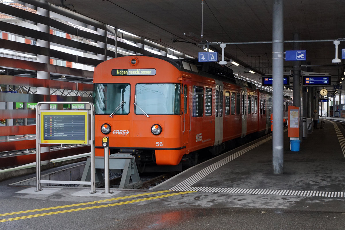 Regionalverkehr Bern Solothurn/RBS.
MANDARINLI  ADIEU.
Endbahnhof Worb-Dorf.
Nach 45 Dienstjahren haben die bekannten Mandarinli, wie sie im Volksmund heissen ausgedient.
Während diesen vielen Jahren prägten sie das Bild sehr stark im Worblental auf der S 7 Bern – Worb Dorf. In der Woche vom  11. Bis zum 15. Dezember 2019 standen sie ein letztes Mal im Plandienst, damit sich die Fahrgäste und die Eisenbahnfreunde von ihnen verabschieden konnten.  Die beiden letzten Triebzüge Be 4/12 56 und Be 4/12 57 werden zwar vorerst nicht verschrottet, da sie noch als eiserne Reserve zurückbehalten werden. Da ich zusammen mit diesen eleganten orangen Triebzügen  den grössten Teil  meines Lebens verbringen  konnte, freue ich mich über sehr viele Abschiedsbilder unter BB.de.  Ich werde meinen Beitrag leisten. Ich verabschiedete mich am Freitag den 13. Dezember 2019 zusammmen mit mehreren Bahnfreunden.  
So himmeltraurig das Wetter, so traurig der Abschied von diesem Zug.  Nicht nur das Taschentuch sondern auch meine Kleider waren durch und durch nass.
Mandarinli adieu!
Foto: Walter Ruetsch
