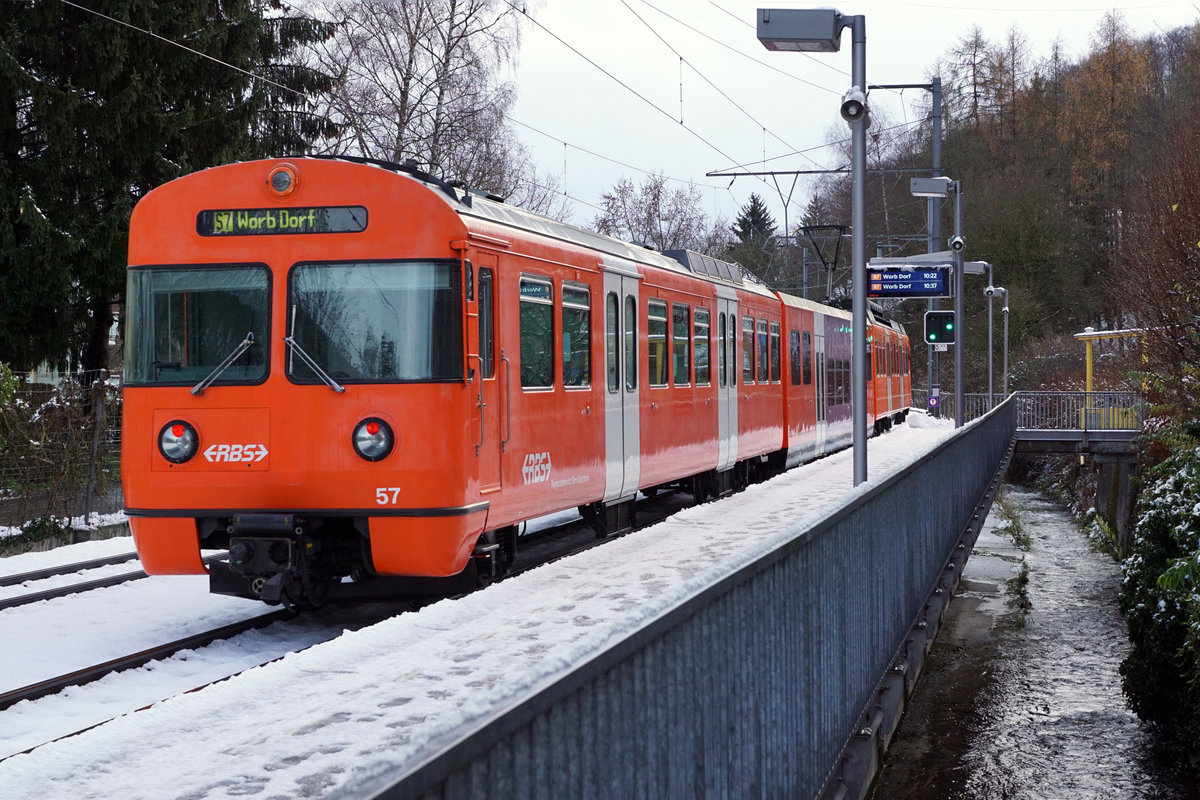 Regionalverkehr Bern Solothurn/RBS.
MANDARINLI  ADIEU.
Nach 45 Dienstjahren haben die bekannten Mandarinli, wie sie im Volksmund heissen ausgedient.
Während diesen vielen Jahren prägten sie das Bild sehr stark im Worblental auf der S 7 Bern – Worb Dorf. In der Woche vom  11. Bis zum 15. Dezember 2019 standen sie ein letztes Mal im Plandienst, damit sich die Fahrgäste und die Eisenbahnfreunde von ihnen verabschieden konnten.  Die beiden letzten Triebzüge Be 4/12 56 und Be 4/12 57 werden zwar vorerst nicht verschrottet, da sie noch als eiserne Reserve zurückbehalten werden. Da ich zusammen mit diesen eleganten orangen Triebzügen den grössten Teil  meines Lebens verbringen  konnte, freue ich mich über sehr viele Abschiedsbilder unter BB.de.  Ich werde meinen Beitrag leisten. Ich verabschiedete mich am Freitag den 13. Dezember 2019 zusammmen mit mehreren Bahnfreunden.  
So himmeltraurig das Wetter, so traurig der Abschied von diesem Zug.  Nicht nur das Taschentuch sondern auch meine Kleider waren durch und durch nass.
Mandarinli adieu!
Foto: Walter Ruetsch
