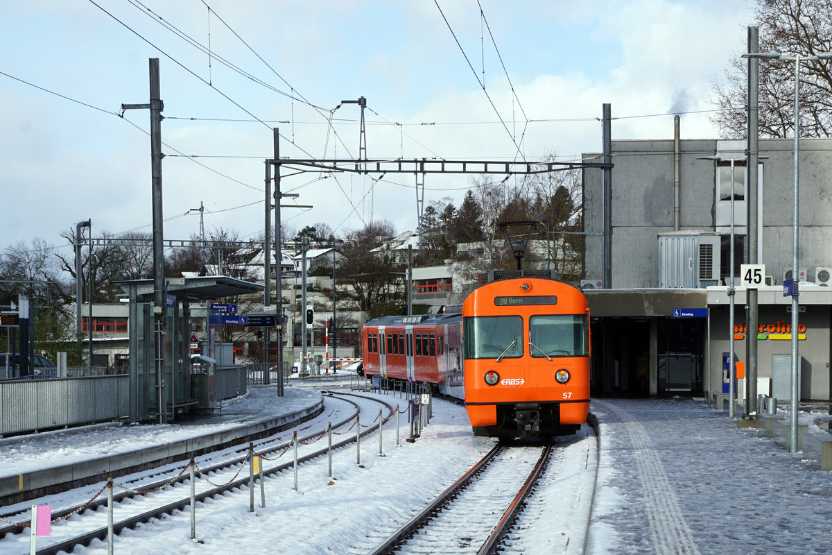 Regionalverkehr Bern Solothurn/RBS.
MANDARINLI  ADIEU.
Nach 45 Dienstjahren haben die bekannten Mandarinli, wie sie im Volksmund heissen ausgedient.
Während diesen vielen Jahren prägten sie das Bild sehr stark im Worblental auf der S 7 Bern – Worb Dorf. In der Woche vom  11. Bis zum 15. Dezember 2019 standen sie ein letztes Mal im Plandienst, damit sich die Fahrgäste und die Eisenbahnfreunde von ihnen verabschieden konnten.  Die beiden letzten Triebzüge Be 4/12 56 und Be 4/12 57 werden zwar vorerst nicht verschrottet, da sie noch als eiserne Reserve zurückbehalten werden. Da ich zusammen mit diesen eleganten orangen Triebzügen  den grössten Teil  meines Lebens verbringen  konnte, freue ich mich über sehr viele Abschiedsbilder unter BB.de.  Ich werde meinen Beitrag leisten. Ich verabschiedete mich am Freitag den 13. Dezember 2019 zusammmen mit mehreren Bahnfreunden.  
So himmeltraurig das Wetter, so traurig der Abschied von diesem Zug.  Nicht nur das Taschentuch sondern auch meine Kleider waren durch und durch nass.
Mandarinli adieu!
Foto: Walter Ruetsch
