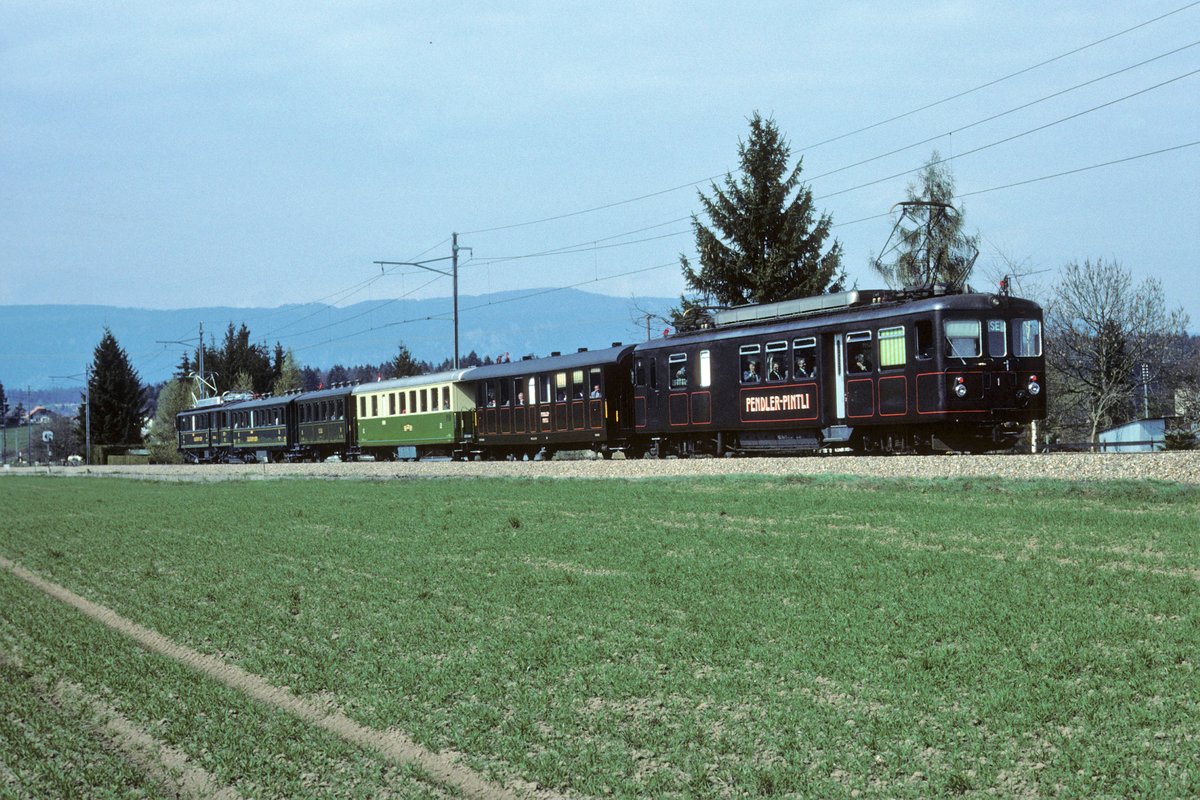 Regionalverkehr Solothurn-Bern RBS/SZB.
75 JAHRE RBS/SZB/ESB.
Sonderzug Worblaufen-Solothurn für geladene Gäste.
Der längste Nostalgiezug aller Zeiten wurde formiert aus:
Bre 4/4 1, Br 317, AB 41, C2 78, C4 61 und dem CFe 4/4 11  HOSCHTET-SCHNÄGG  der zum Jubiläum als historischer Triebwagen hergerichtet wurde. Von den Wagen befindet sich nur noch der C4 61 im Bestand von RBS-Historic. Die übrigen Wagen wurden von La Traction übernommen.
Besondere Beachtung gilt den beiden  PENDLER PINTLI  im selben Zug. 
Die Aufnahme ist im Sommer 1991 im Limpachtal entstanden.
Foto: Walter Ruetsch  