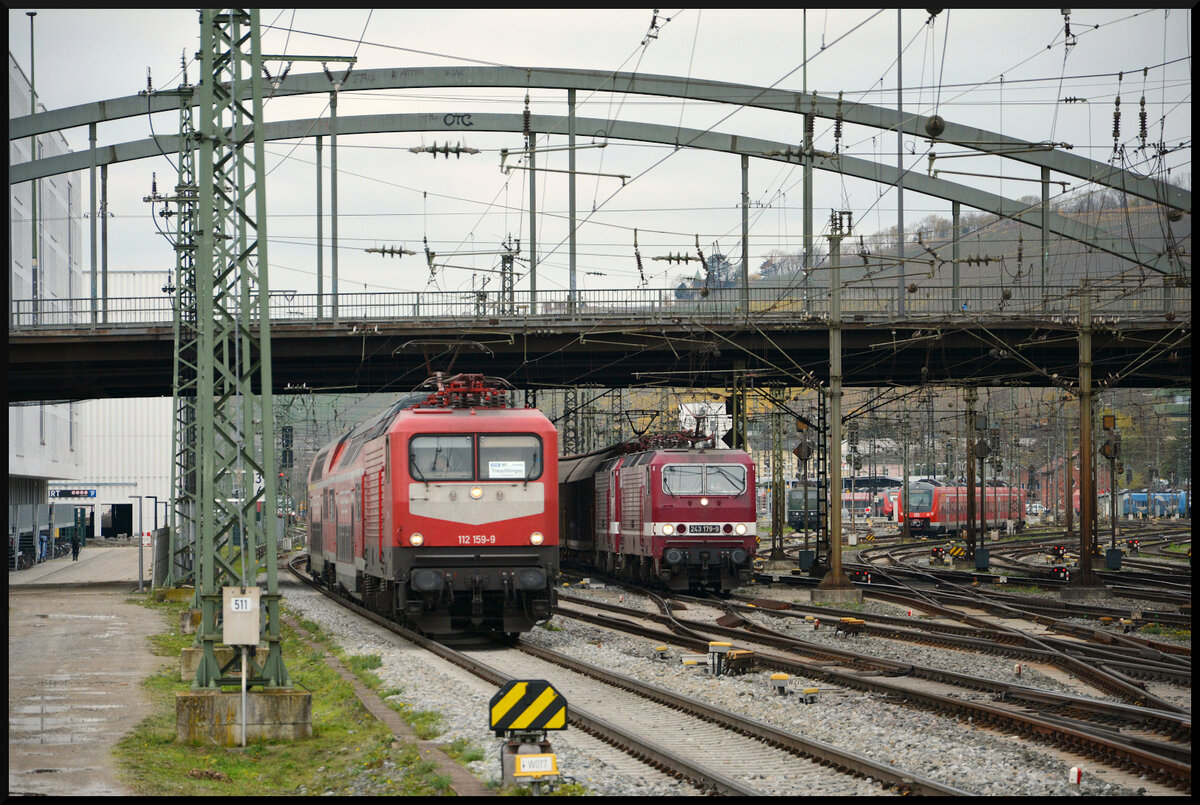 Reichsbahn-Feeling: Die beiden Delta Rail 243 931 & 179 sind am 22.11.2023 mit einem Habis-Ganzzug auf dem Weg nach Nürnberg Hafen, als sie sich in Würzburg bei der Ausfahrt aus dem dortigen Hbf ein Wettrennen mit der WFL 112 159 und ihrem RE80-Ersatzzug (zwei exDR Dostos) nach Treuchtlingen liefern. Im Hintergrund schaut die SRI 151 124 chancenlos zu, da sie kalt auf Gleis 455 abgestellt ist.
