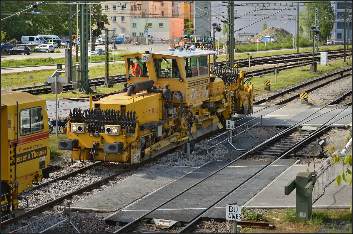 Renovation von Deutschlands letztem Kilometer. Die Gleisbaumaschine steht in zwei Ländern. Der hintere Bahnübergang ist gerade noch in Deutschland. Mai 2014.