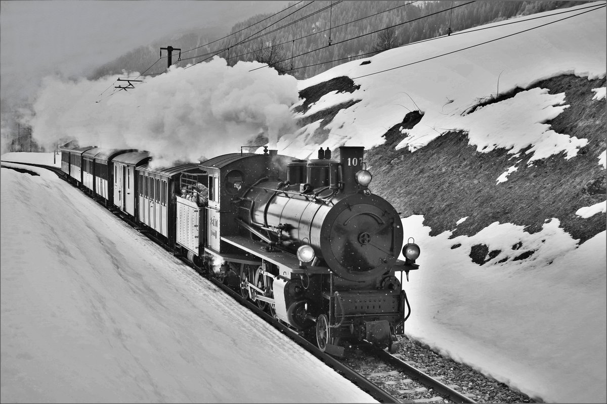 RhB Dampffahrt ins Surselva: RhB G 4/5 107  Albula  unterwegs mit dem Dampfextrazug 2723 bei der Rückfahrt von Disentis-Mustér - Landquart kurz nach Sumvitg-Cumpadials. 
Aufnahme in S/W.

Sonntag, 25. Februar 2018