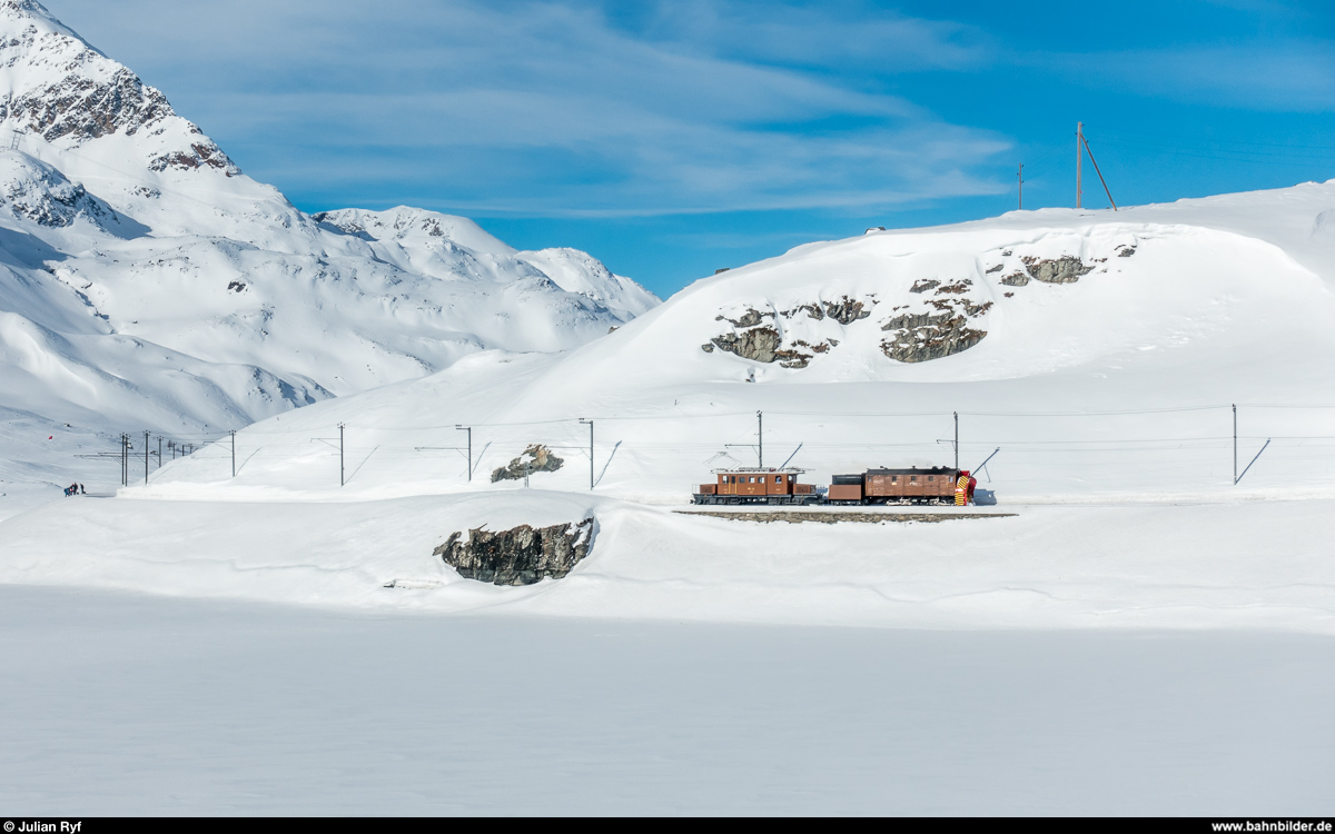 RhB Dampfschneeschleuderfahrt am 28. Januar 2018. <br>
Die Ge 4/4 182 schiebt die Xrotd 9213 von der ersten Schleuderfahrt bei der Wasserscheide zurück nach Ospizio Bernina dem schneebedeckten Lago Bianco entlang.