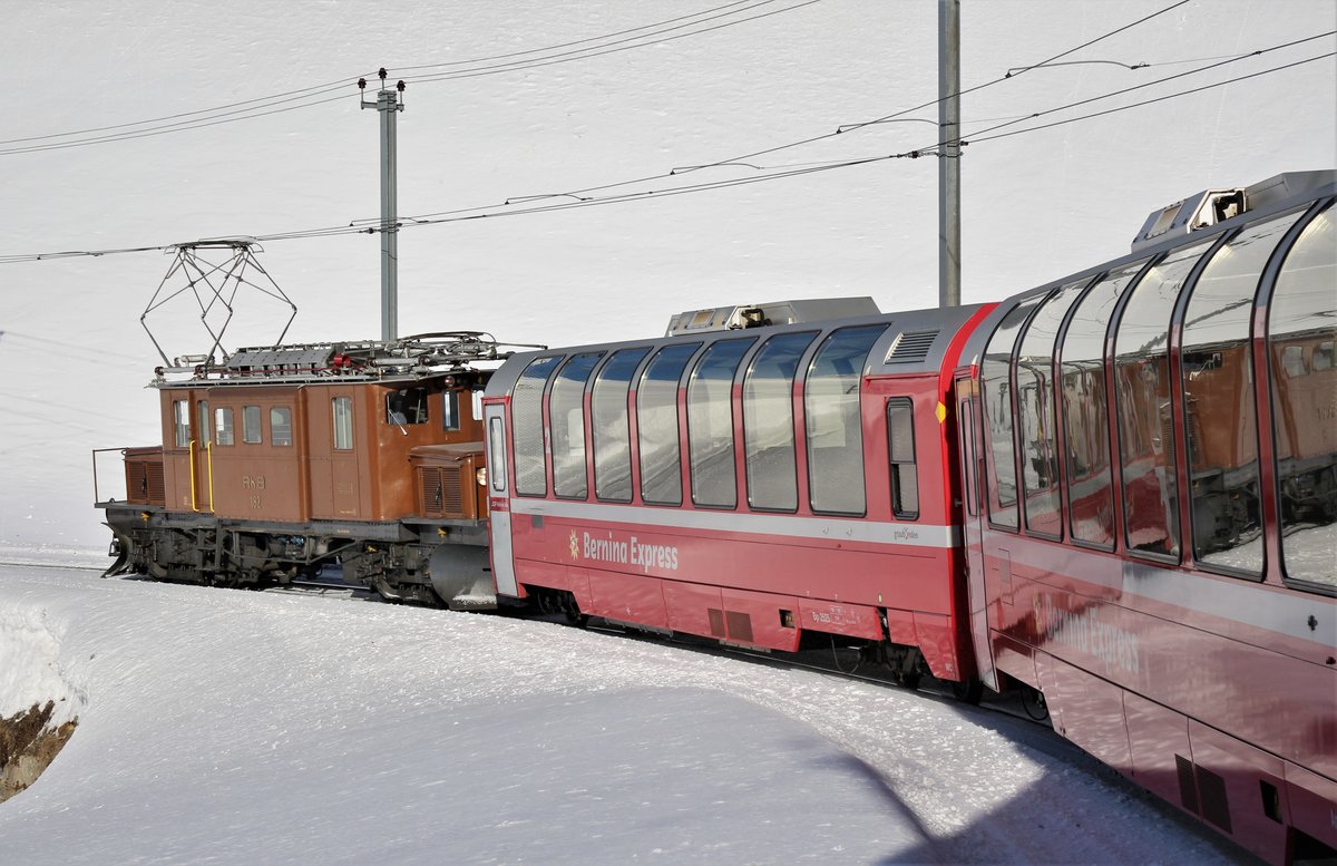 RhB: Das legendäre  Bernina-Krokodil  Ge 4/4 Nr. 182 durfte am 28. Januar 2018 am Zugschluss des Bernina-Express (BEX) von Pontesina nach Ospizio Bernina mitfahren. Es handelte es sich um eine Überfuhr der Lok anlässich der Dampfschneeschleuderfahrt am Berninapass.

Das Bild entstand von einem Regionalzug bei einer starken rechts-Kurve kurz vor Ospizio Bernina. Ab Ospizio Bernina wurde dann das Bernina-Krokodil abgekoppelt und die im Bild zusehenden Panoramawagen fuhren weiter als R nach Tirano.