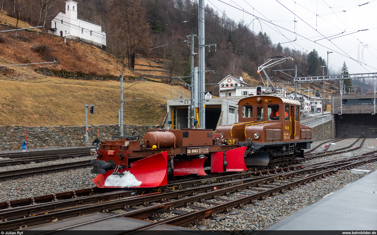 RhB Ge 2/2 161 / Poschiavo, 10. Februar 2024<br>
Der Spurpflug Xk 9143 wird an den soeben eingefahrenen Regio Tirano - St. Moritz rangiert für die Fahrt über den schneebedeckten Berninapass.