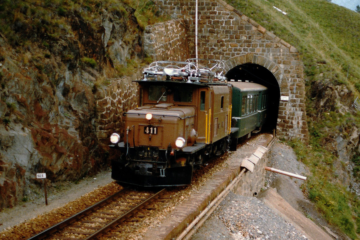 RhB: Ge 6/6 I 411 mit ihrem Güterzug mit Personenbeförderung bei St. Moritz unterwegs im Oktober 1987.
Foto: Walter Ruetsch 