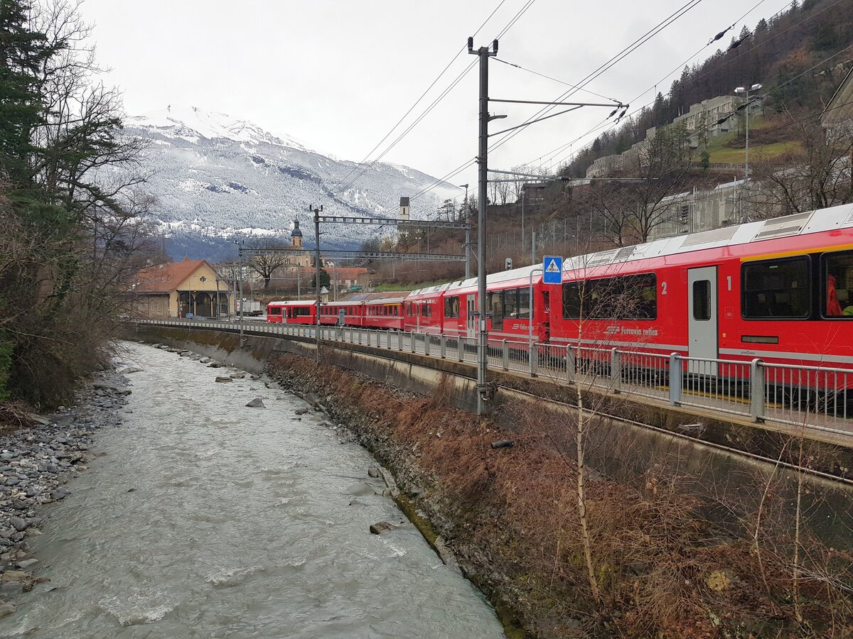 RhB_Chur-Arosa__Blick über die Plessur Richtung Chur mit ehemaligem RhB-Depot. Nach einstündiger Bergfahrt ist wieder eine Zugladung Wintersportler im tiefen Neu-Schnee ! __23-02-2024