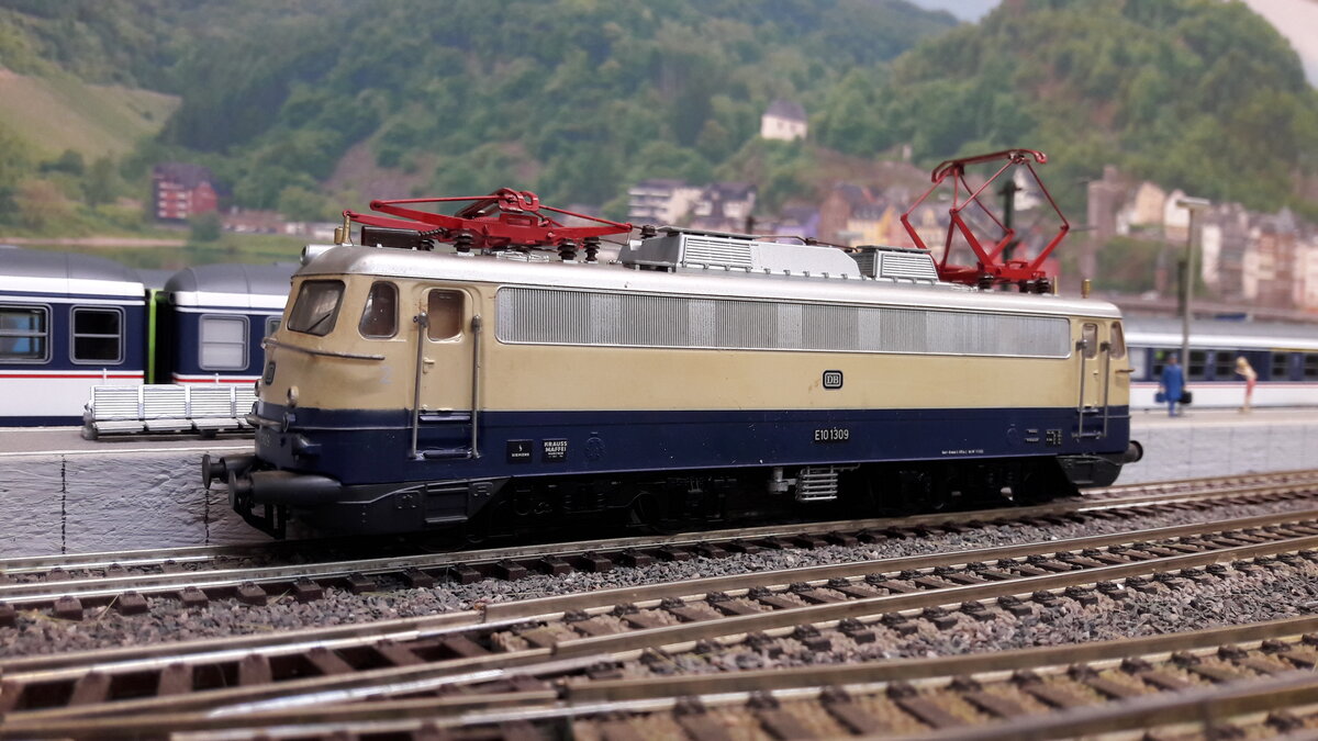 Rheingold Lokomotiven , als E10 Kasten und Bügelfalten E10 ( später 112)….
Die geplante E10 Bügelfalte war noch nicht fertig gestellt, da wurden einige E10 Kasten in Rheingoldlackierung als Provisorium umgebaut….. Provisorium 1 :  6 Loks ( 239-244) mit Getriebumbau auf 160 km/h , sie bekamen eine 1 vor der Ordnungsnummer also E10 1239 -1244 . Die 1244 bekam ein sogenanntes Henschel – Drehgestell was sie auch behielt.
Da die E10 Bügelfalte immer noch nicht fertig war, orderte man nochmal 5 Loks der Kasten E10 nach ( Provisorium 2 )  , welche direkt mit Henscheldrehgestellen ausgeliefert wurden.  E10 250-254 . Diese bekamen keine 1 davor, also wie gehabt E10 250-254 …. Zu unterscheiden waren Provisorium 1 und 2 unter anderem auch an der Beschriftung. Provisorium 1 hatte vorne den DB Keks und an der Seite keinen.  Provisorium 2 umgekehrt, vorne kein Keks, dafür an Seite. …. Ab 1962 gab es dann die ersten Bügelfalten E10 in Rheingoldausführung.  6 Loks  E10 1239-1270, diese hatten keine Rehling vorne .  Ab 1963 dann die nächste Lieferung E10 1308-1012  welche nun aber eine Rehling vorne hatten. Ab 1966 wurden die blau/ elfenbein lackierten Loks in TEE Farben umlackiert. Deswegen gab es auch mit E10  1308  usw , beschriftete E10er Bügelfalten in TEE Farben….1968 gab es dann die 3. Lieferung von 20 Loks  E10 485-504 welche aber direkt als 112 er Loks in TEE Farben ausgeliefert wurden. Alle Kasten Rheingold E10 wurden später wieder in blau zurück lackiert.  Hier das Modell der zweiten Serie, Bügelfalten E10, E10 1309, Regenrinne, diesmal Rehling vorne, Pufferverkleidung,  Modell Liliput  DC nachdigitalisiert