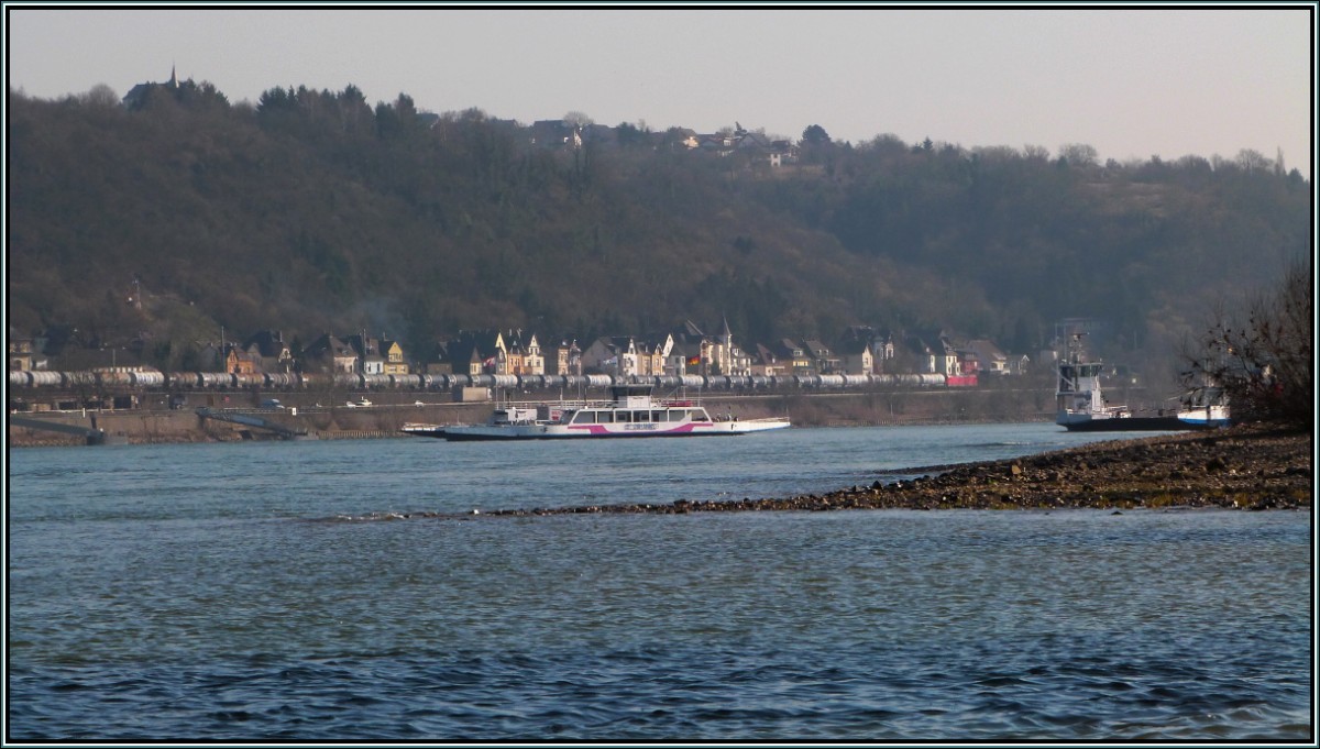 Rheinidylle bei Remagen im März 2013. Die Autofähre bringt ihre Ladung sicher ans andere Ufer,während ein langer Kesselwagenzug durch Linz gen Süden fährt.