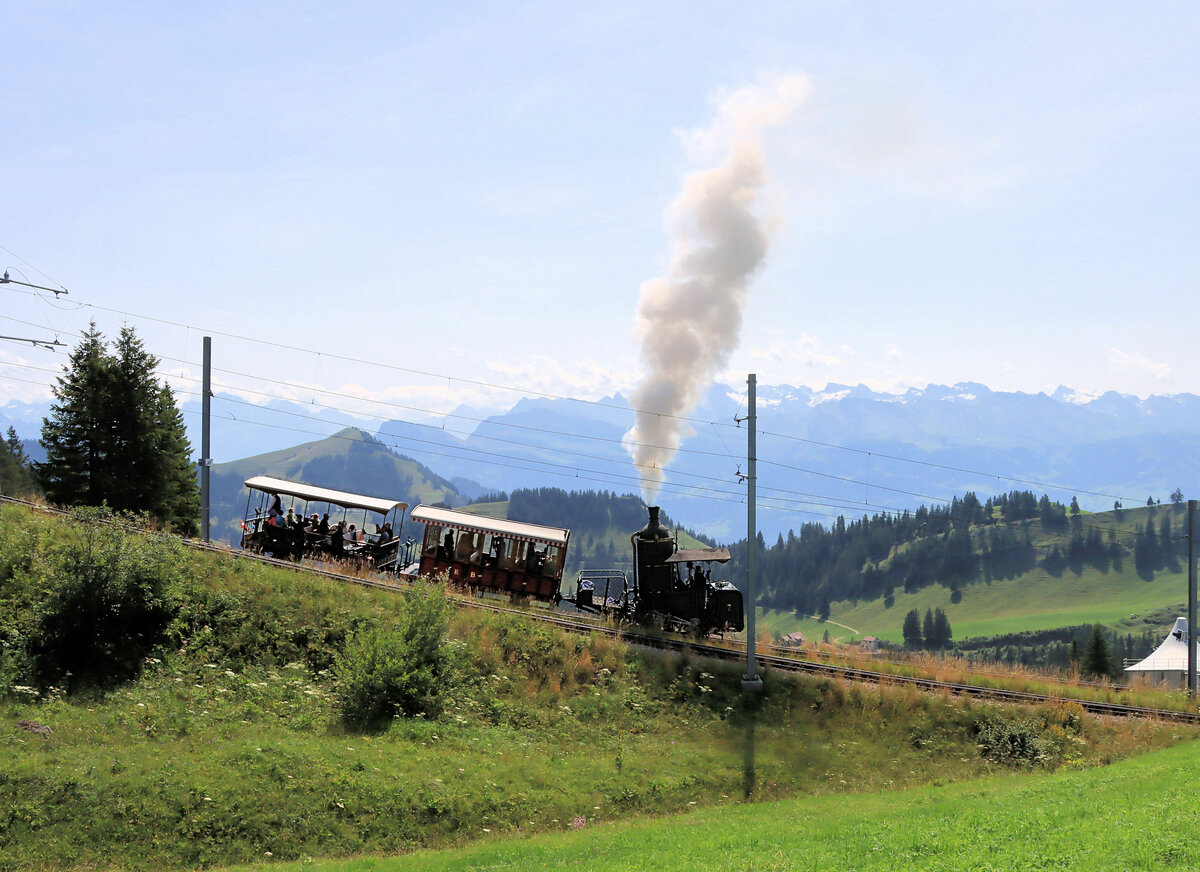 Rigi Bahn zwischen Rigi Staffel und Rigi Kulm - Silhouettenbild: Hoch in den Himmel steigt der Dampf des historischen Zugs mit der Stehboiler-Lokomotive H1/2 7 von 1873. Der Kessel ist 1995 neu gefertigt worden. 21.August 2021 