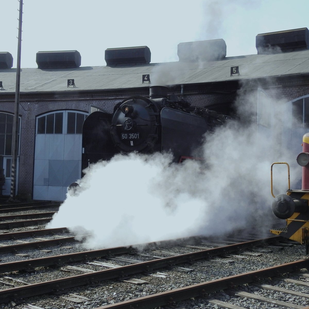 RINGLOKSCHUPPEN SIEGEN MIT DAMPFLOK 50 3501(EF TREYSA)
Am 25.3.2018 rollt Güterzug-Dampflok 50 3501 der EF TREYSA nach ihrer Jubiläumsfahrt
über die Strecke der HELLERTALBAHN nach SIEGEN nachmittags nach erfolgter Wartung
mit schönem Fotodampf heraus aus dem Lokschuppen zur Drehscheibe,
um sich wieder vor die Waggons des Sonderzuges zu setzen....