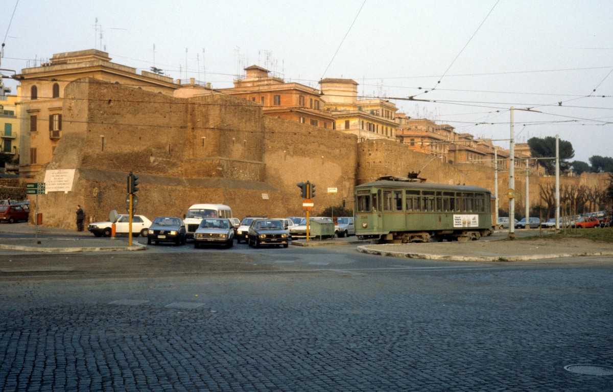 Roma / Rom ATAC SL 30/ Piazza Ostiense im Februar 1989. - Auf dem Bild ist ein kleiner Teil der Aurelianischen Mauer zu sehen. Diese Mauer wurde zwischen 272 und 279 unter den Kaisern Aurelianus und Probus errichtet. Sie umfasste die Stadt, war 19 km lang und ursprünglich 6 m hoch und 3,5 m breit; sie hatte 16 Tore und 380 Türme. Später wurde sie verstärkt und erhöht.