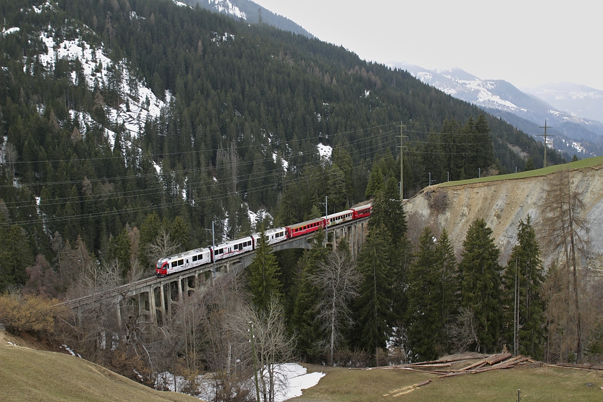 Rund um Langwies bietet nicht nur der gleichnamige Viadukt schöne Motive. In der gleichen Bauweise wie dieser ist auch der Gründjitobel-Viadukt mit einem großen Bogen aus Eisenbeton gebaut. Am 31.03.2022 überquert der ABe 8/12 3512 das 145 m lange und 46 m hohe Bauwerk.