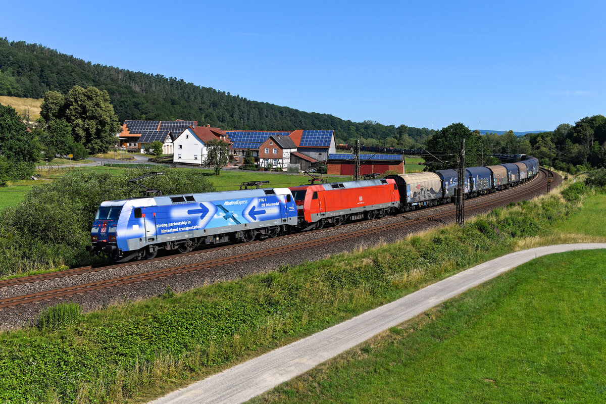  Rush Hour  auf der Nord-Süd-Strecke bei Hermannspiegel im osthessischen Haunetal. Durch die baustellenbedingte Sperre der Neubaustrecke zwischen Fulda und Kassel war in 2023 die Streckenauslastung auf der KBS 610 sehr hoch. Neben den regulär hier verkehrenden Güterzügen zwängten sich auch die umgeleiteten ICEs durch das Nadelöhr. Die Züge verkehrten praktisch im Blockabstand. Am 07. Juli 2023 konnte ich eine typische Szenerie einfangen. Während im Hintergrund der gerade fotografierte WLC-Containerzug verschwindet, kam bereits ein mit einer Doppeltraktion, bestehend aus der  Albatros  152 135 und der verkehrsroten 152 122, bespannter schwerer Stahlzug südwärts gefahren. Den Fotografen auf der Brücke wurde es nicht langweilig.   