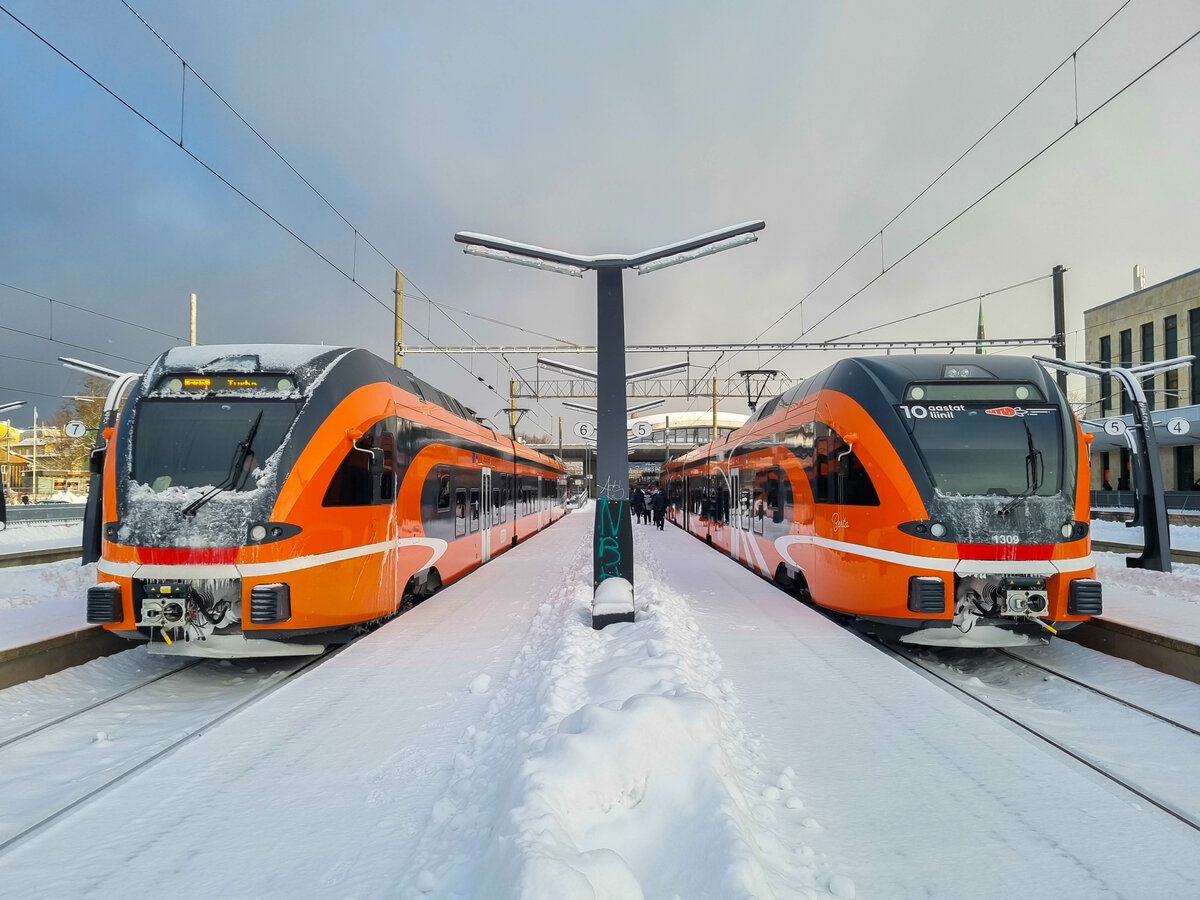 S-Bahn Tallinn  Elron  mit Zug 1310 nach Turba steht neben Zug 1309  Berta  im Baltischen Bahnhof von Tallinn, 04.12.2023.