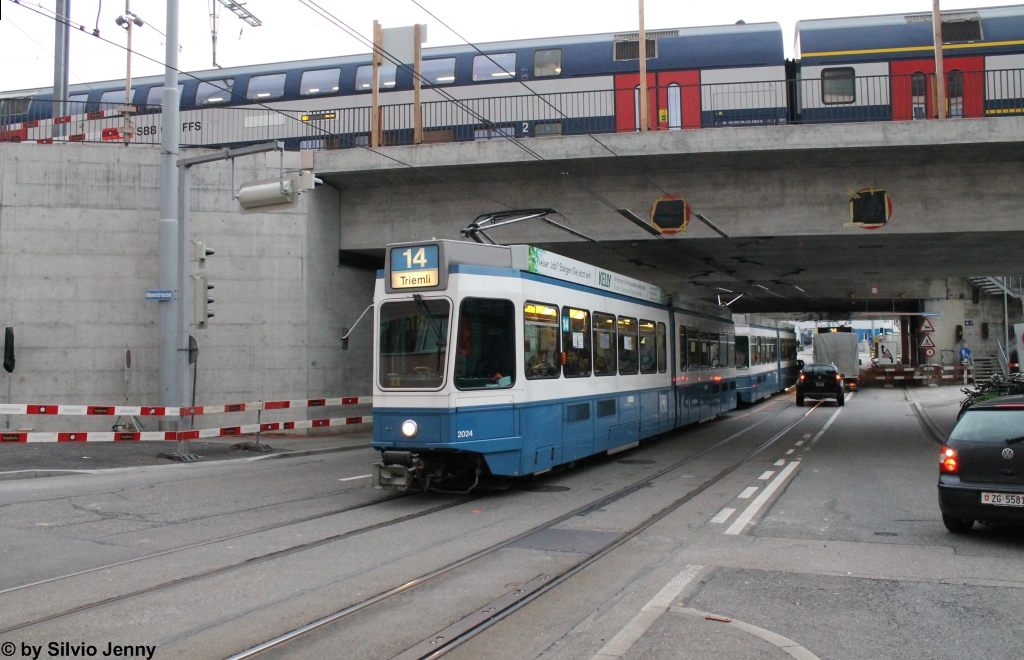 S-Bahn und Tram am 24.1.2015 beim Bahnhof Oerlikon, wo die beiden Be 4/6 2024 + 2013 den Bahnhof Oerlikon unterqueren, während oben eine S8 nach Weinfelden steht.