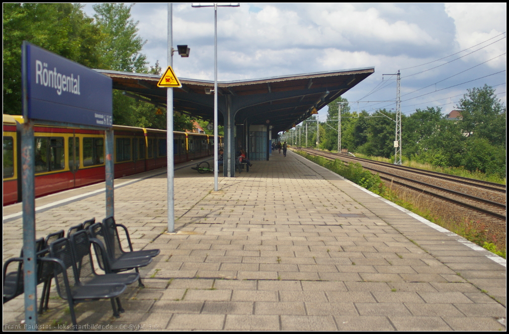 S-Bahnhof Rntgental im Landkreis Barnim. Blickrichtung ist Buch. Das Hauptsignal der Ferngleise steht rund 2 km entfernt ist durch die Bume selbst vom nrdlichen Bahnsteigende kaum zu erkennen (16.06.2014)