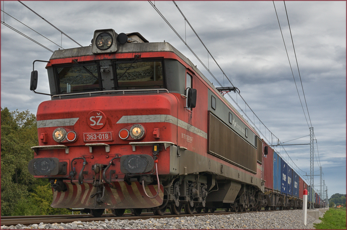 SŽ 363-018 zieht Containerzug an Črešnjevec vorbei Richtung Koper Hafen. /6.9.2017