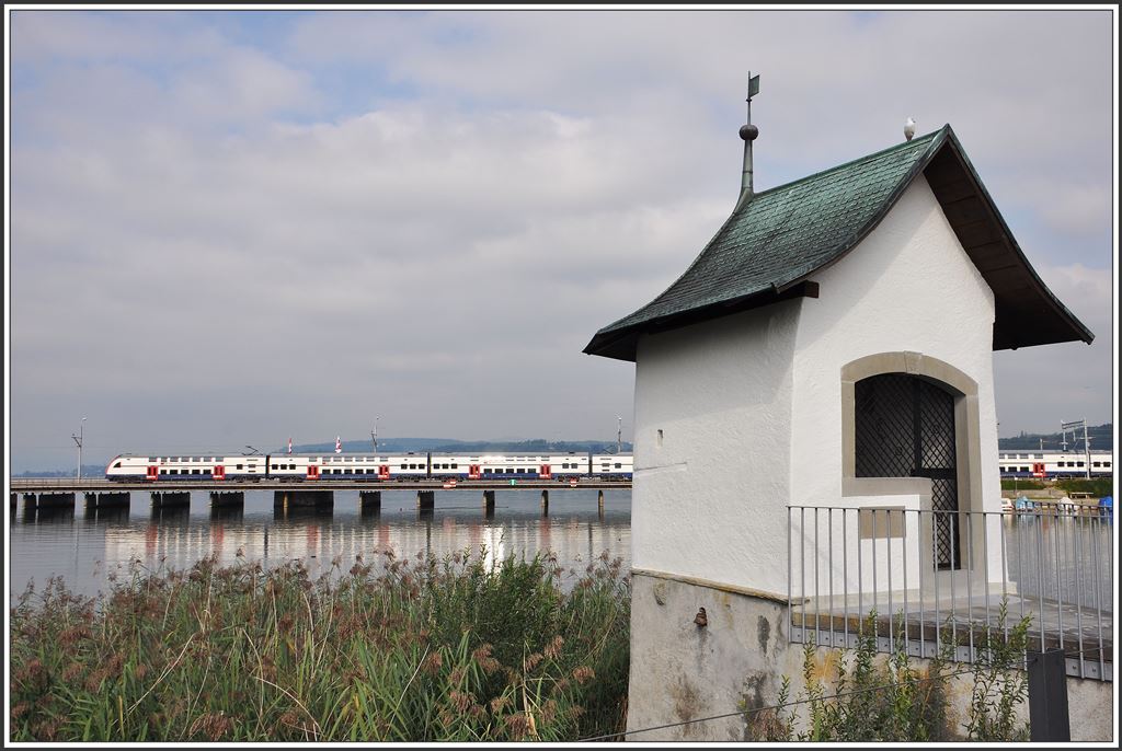 S5 auf dem Weg nach Pfäffikon SZ passiert bei Rapperswil die Kapelle Heilig Hüsli am Fusssteg nach Hurden. (10.09.2015)