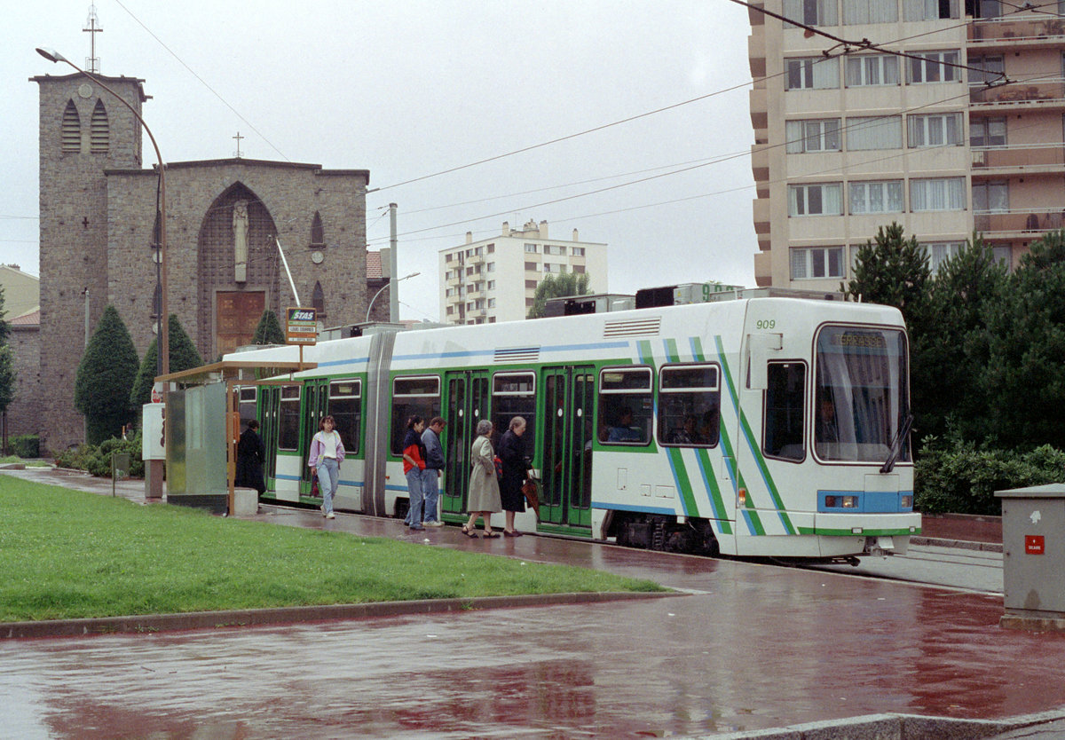 Saint-Étienne STAS Ligne de tramway / SL 4 (Motrice / Tw 909) Place Louis Courrier im Juli 1992. - Im Hintergrund befindet sich die Kirche Notre Dame de la Paix. - Im Dezember 1991 wurden die damals modernen Straßenbahnfahrzeuge 901 - 915 der STAS in Betrieb genommen. GEC Alsthom (F) und Atéliers Mécaniques de Vevey (CH) waren die Hersteller dieses Wagentyps, andere Firmen hatten jedoch auch zur Konstruktion beigetragen: DUEWAG (D), Hanning & Kahl (D), Kiepe (D), Faiveley (F), Saft (F), Hasler (CH), Hannover (GB) und ACEC (B). Die 27,4 t schweren Gelenktriebwagen waren 23,2 m lang und 2,1 m breit und hatten Raum für 204 Fahrgäste (43 Sitzplätze und 161 Stehplätze). Höchstgeschwindigkeit: 70 Stundenkilometer. - Scan eines Farbnegativs. Film: Kodak Gold 200-3. Kamera: Minolta XG-1.  