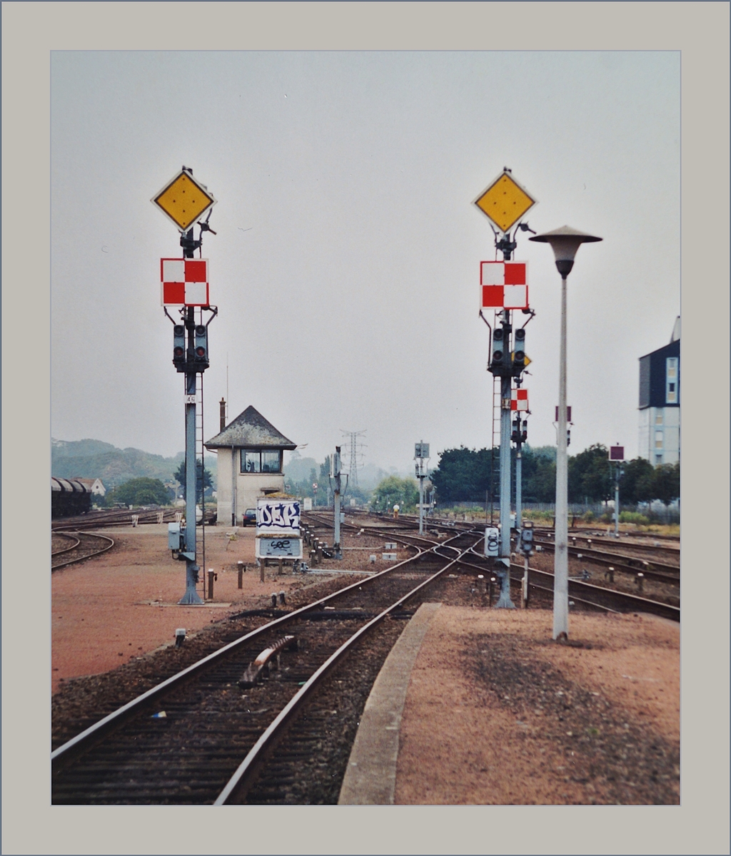Saint-Malo GESTERN und heute: die drei zusammen liegenden Gemeinden Saint-Malo, Saint-Servan und Paramé taten sich bereits 1840 zusammen um ihren Wunsch eine Anbindung an die künftige Ost-West Strecke durch die Bretagne Kund zu tun. 
1864 dan war es so weit, die 81 km lange Strecke Rennes - Saint-Malo wurde eröffnet, zwei ein halb Stunden dauerte die Fahrt. 
Die Lage des Bahnhofs wurde so gewählt, dass die Distanz zu den drei Gemeinden in etwa gleich war. 

Das Analog Bild vom August 2001 zeigt zwei Ausfahr-Formsignale im  alten  Bahnhof von St-Malo.

24. Aug. 2001