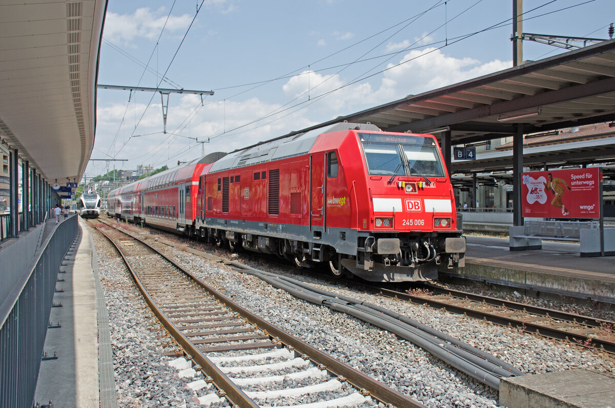 Samstag den 17.06.2023 um 14:00 Uhr in Schaffhausen. Auf Gleis 5 steht der Abfahrbereite IRE 3 (Interregio-Express) mit der Zugnummer IRE 3056 nach Basel Bad Bf. Er verkehrt von Friedrichshafen Stadt (Abfahrt um 12:45 Uhr) über Radolfzell – Singen (Hohentwiel) – Schaffhausen – Erzingen (Baden) - Waldshut nach Basel Bad Bf (Ankunft um 15:12 Uhr). Als Zuglok dient die Diesellok 245 006 (92 80 1245 006-2 D-DB). Es handelt sich hier um eine Lok des Typs TRAXX P160 DE ME von Bombardier. Die Lokomotive verfügt über vier kleinere Dieselmotoren (ME = Multi Engine) statt eines grossen Dieselmotors. Der Name Traxx steht für locomotives platform for transnational railway applications with extreme flexibility (deutsch Lokomotivplattform für nationenübergreifende Eisenbahnanwendungen mit extremer Flexibilität). Somit ist es eine echte Bo'Bo'-de statt eine B’B’-de und hat damit vier unabhängige Einzelachsantriebe. Baujahr: 2013. Fabriknummer: 35005. Koordinaten GMS (Grad, Minuten, Sekunden): N 47° 41’ 51.9’’ O 8° 37’ 53.5’’