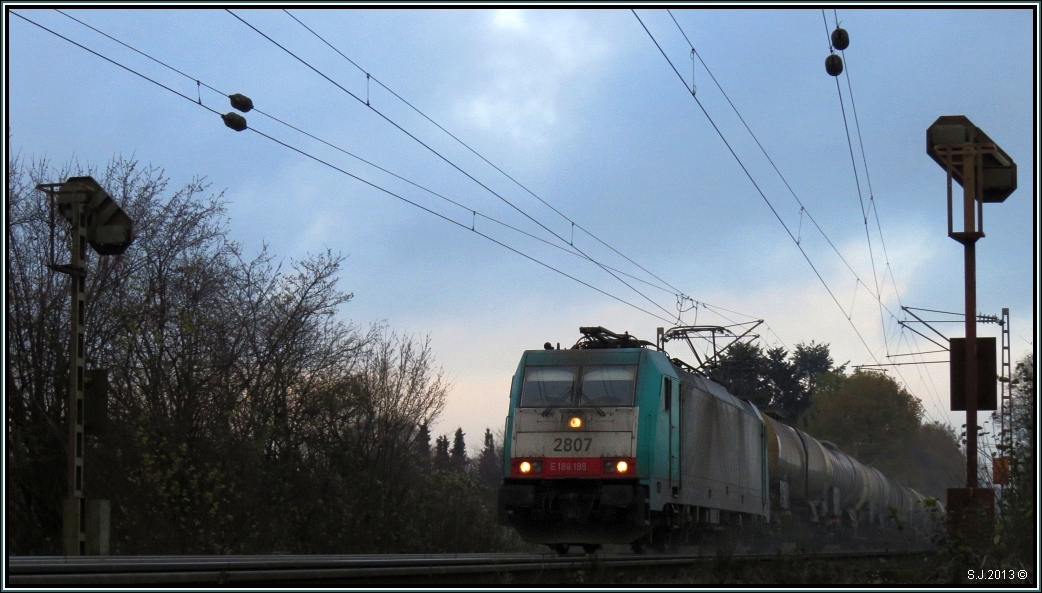 Sand gibt es nicht nur am Strand,hier wird er als wichtiges Betriebsmittel eingesetzt um die Rampe hinauf zum Gemmenicher Tunnel zu bewerkstelligen. Die belgische 2807 mit schwerer Last am Haken auf der Montzenroute bei Aachen. Bildlich festgehalten am 01.Dezember 2013. 