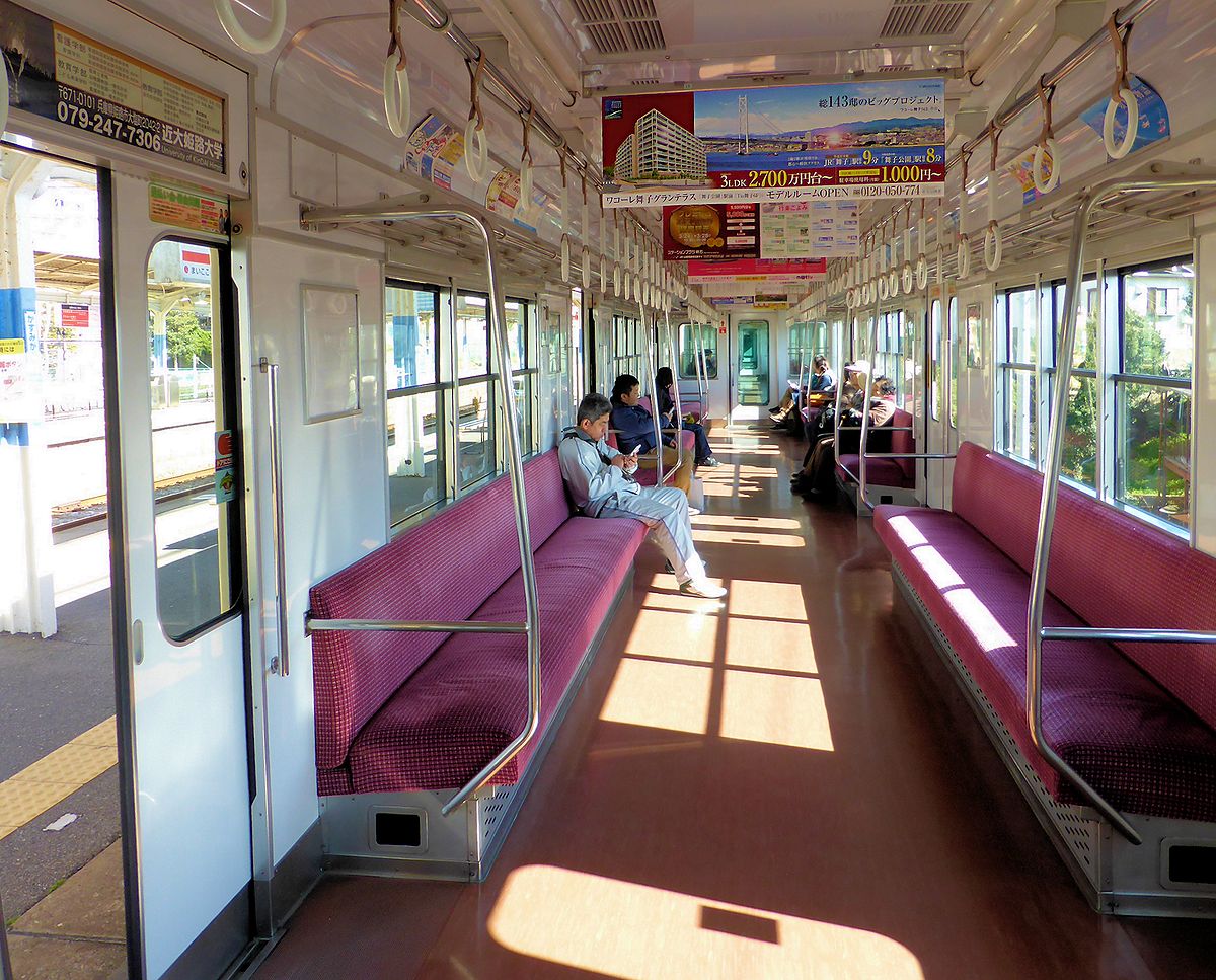 Sanyô-Konzern: Im Inneren des Lokalzugs 3058 (Baujahr 1972). Konzerne wie Sanyô, in deren Mittelpunkt ein Bahnbetrieb steht, sind stets überaus aktiv im Immobilienbereich; entsprechend hängt an der Decke eine grosse Werbetafel für Immobilien an der schönsten Stelle der Linie unmittelbar bei der riesigen Inlandsee-Brücke zur Insel Awajishima und dann weiter nach Shikoku. 22.März 2014. 