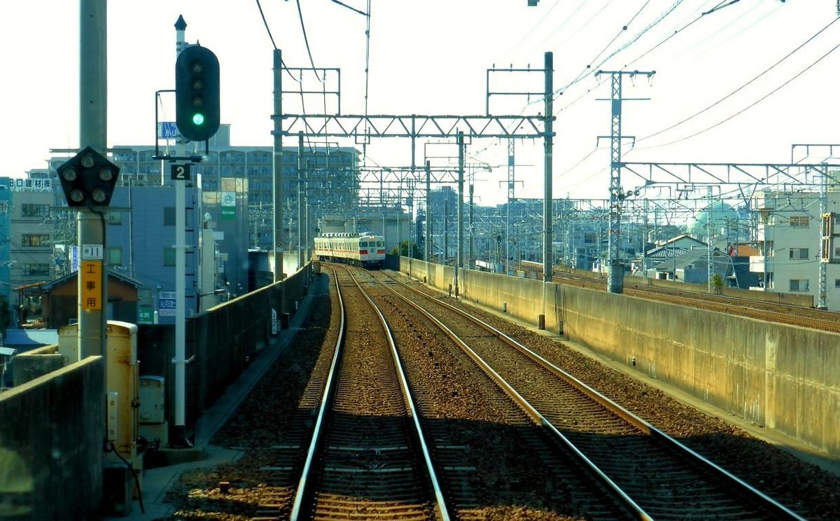 Sanyô-Konzern: In diesem Bild sieht man wie die JR-Linien (rechts) und der Sanyô-Konzern weitgehend parallel verlaufen, wobei der Sanyô-Konzern wesentlich mehr Haltestellen aufweist. Im Bild kommt Sanyô-Lokalzug 3062 (Baujahr 1972) in der Stadt Akashi entgegen, 22.März 2014.  