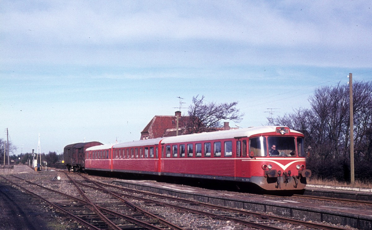 SB, Skagensbanen: Ein Triebzug bestehend aus einem Steuerwagen (Ys), einem Personenwagen (Yp) und einem Triebwagen (Ym) - alle wurden von der Waggonfabrik Uerdingen AG gebaut - samt einem Güterwagen hält in Jerup am 25. Februar 1975.  