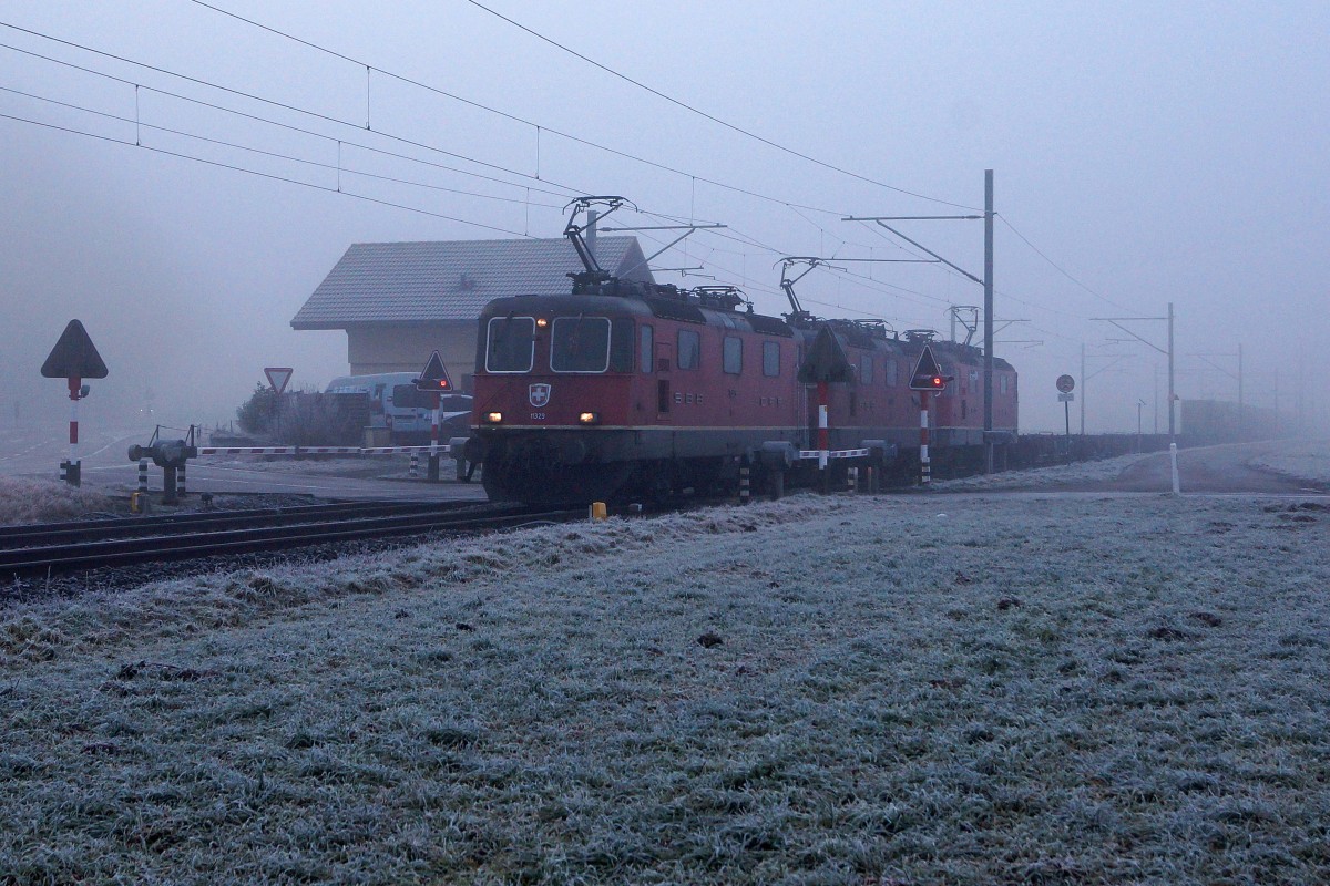 SBB: Bei kaltem und sehr nebligem Wetter passierte ein SBB-Güterzug mit einer Dreifachtraktion Re 4/4 II am Sonntag Morgen des 18. Januar 2015 den abgelegenen Bahnübergang bei Bettenhausen mit dem ehemaligen typischen Bahnwäterhäuschen, das bereits vor mehreren Jahren umgenutzt wurde.
Foto: Walter Ruetsch   
