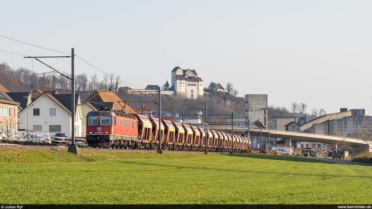 SBB Cargo Re 6/6 11614 mit Kieszug Rothenburg - Zweidlen am 8. März 2021 bei Holderbank. Im Hintergrund das Schloss Wildegg.