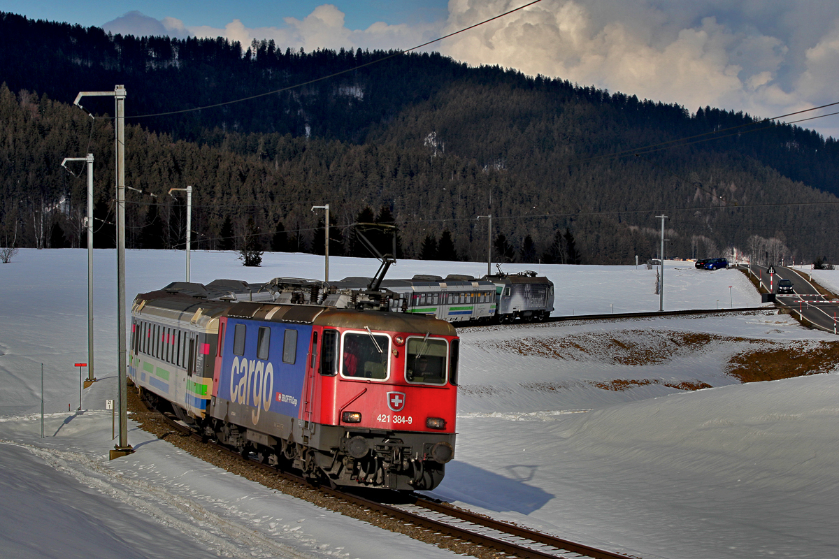 SBB Cargo Zuglok 421 384-9 mit der Schublok Re 446 017 fahren mit dem Voralpenexpress bei Altmatt vorüber.Bild vom 25.2.2015