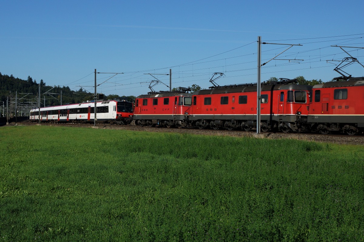 SBB:  FOTOGRAFENGLUECK  Zufällige Begegnung zur richtigen Sekunde zwischen der S 23 mit RBDe 560 Kolobri/Domino (auf der Fahrt zum Endhalt Langenthal) und einem Güterzug aus dem Süden mit einer roten Re 20/20 bei Roggwil am 26. August 2015.
Foto: Walter Ruetsch
