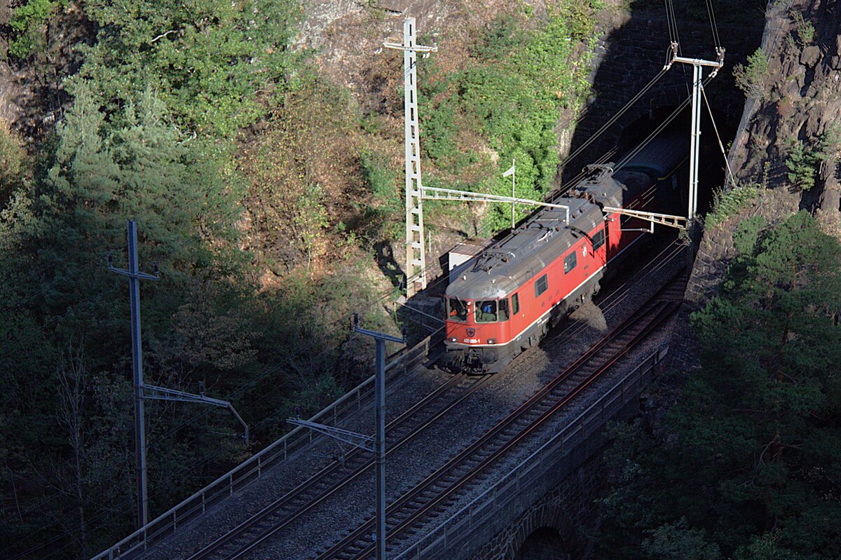 SBB Historic f�hrt Fahrten mit historischen Lokomotiven durch, auch am Gotthard. Am 12.08.2026 wurde eine Re 6/6 eingesetzt. Diese Maschinen sind also auch schon historisch, sind aber zur Zeit auch noch im Alltag unterwegs. Da merkt man, wie man alt wird, zu meiner Gymnasialzeit waren sie neu.
Die Lok verl�sst gerade den kurzen Tunnel bei Silenen und �berquert gleich das Maderanertal �ber den Ch�rstelenbachviadukt.