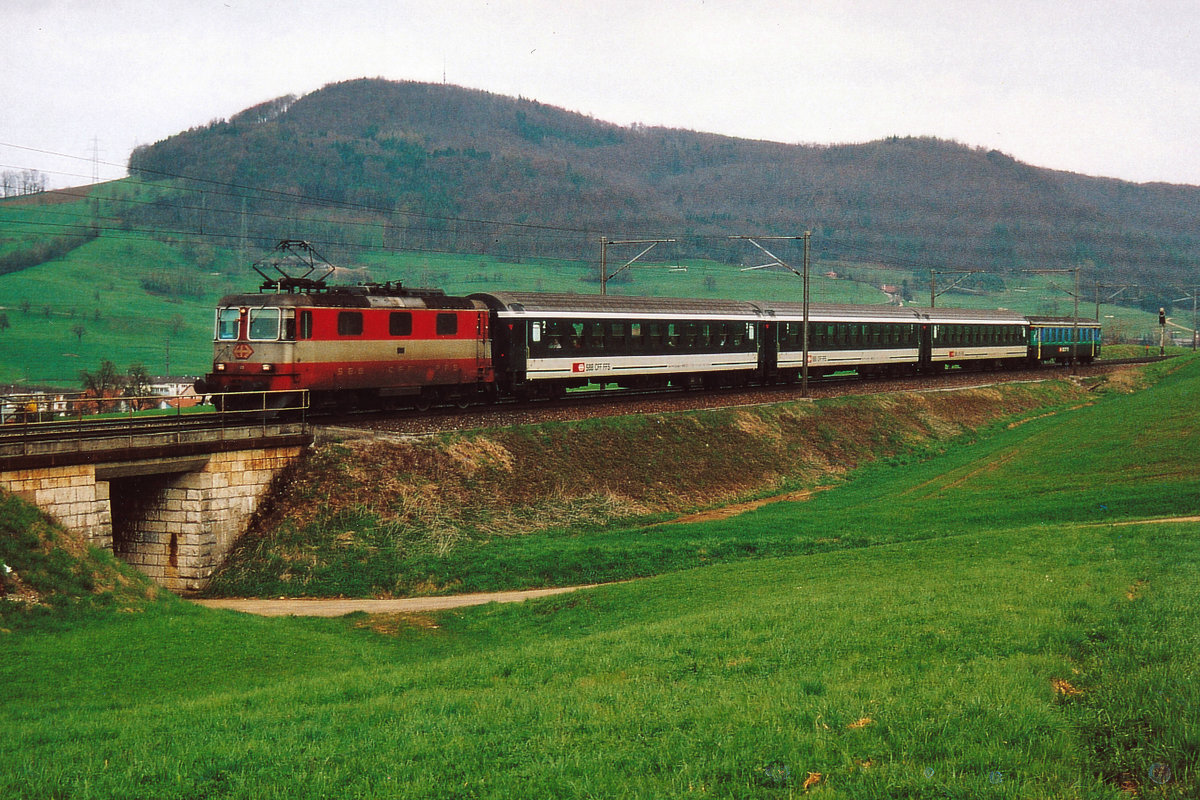 SBB: Kurzzug Basel-Zürich mit der Re 4/4 II 11141  SWISS EXPRESS  bei Frick am 18. April 2006. Dieser Zug bestehend aus nur vier älteren Personenwagen verkehrte während mehreren Jahren auf dieser Strecke mit einer Re 4/4 II.
Foto: Walter Ruetsch