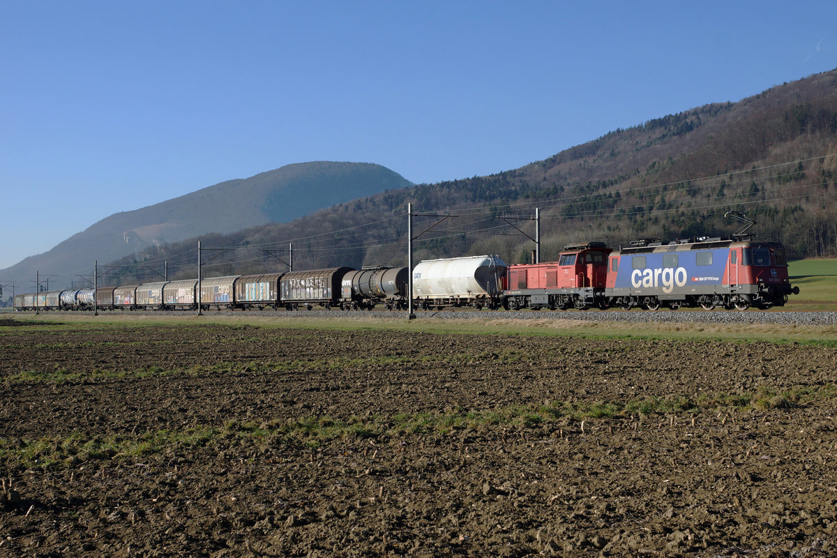 SBB: Re 421 385-6 und Bm 4/4 18432 mit Güterzug zwischen Oensingen und Oberbuchsiten am 28. Dezember 2016.
Foto: Walter Ruetsch