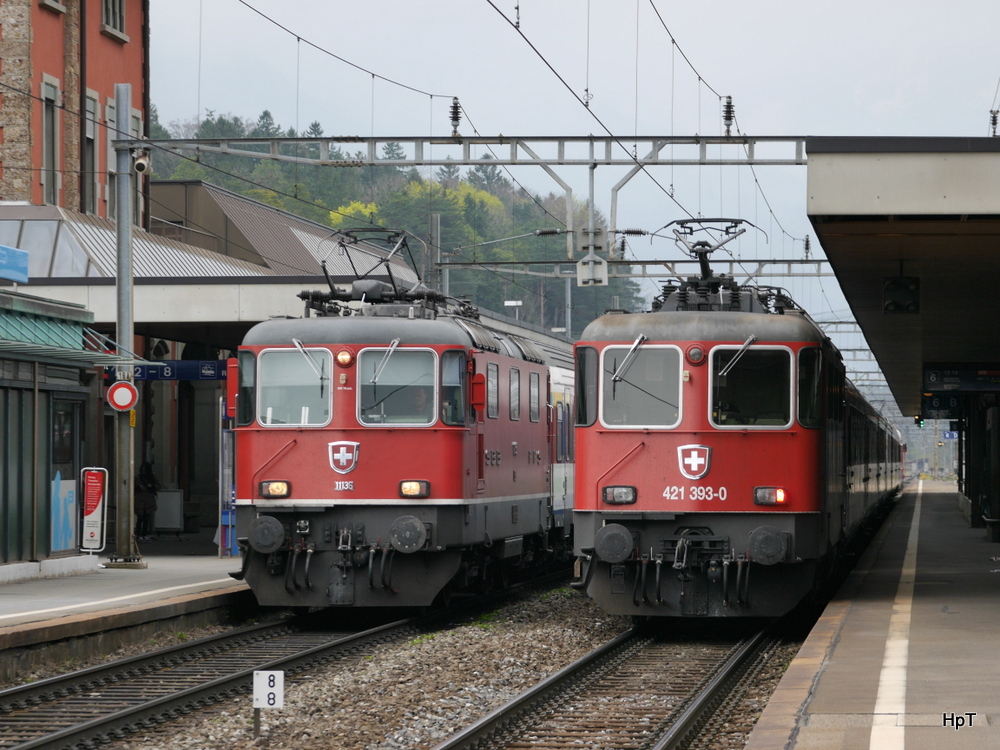 SBB - Re 4/4  11136 mit Schnellzug nach Basel neben der 421 393-0 im Bahnhof von Goldau am 05.04.2014