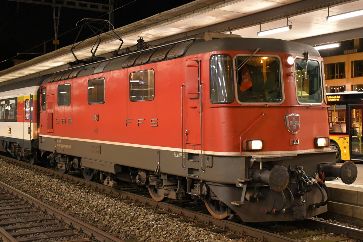 SBB Re 4/4 II 11121 beim Halt in Brugg mit ihrem Interregio nach Zürich HB am Abend des 07.12.2019.