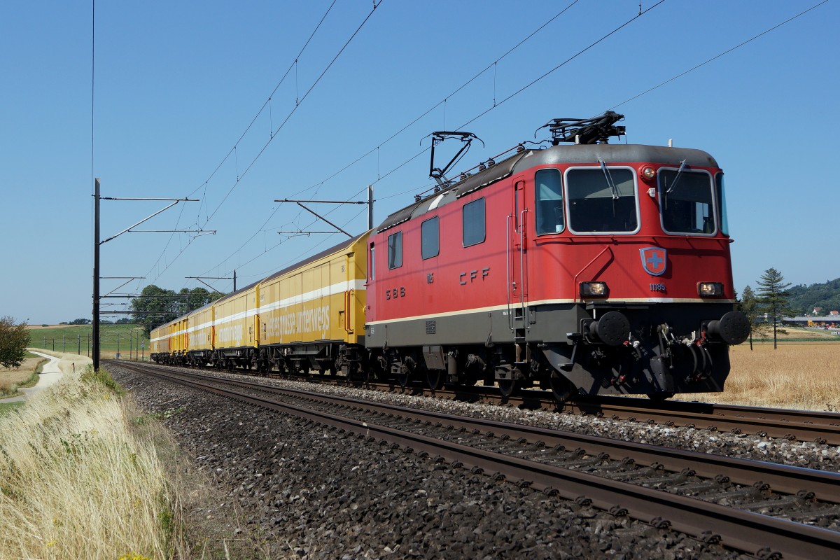 SBB: Re 4/4 II 11185 mit Postwagen bei Niederbipp in Richtung Härkingen unterwegs am 10. Juli 2015.
Foto: Walter Ruetsch
