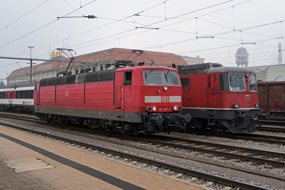 SBB/DB: Die DB 181-207 (Ffm-Griesheim) und die SBB Re 4/4 11151 warten am 24. Oktober 2013 in Singen auf die Uebernahme der IR von Zürich und von Stuttgart. Während die SBB für diese Dienste nur Re 4/4 einsetzt sind, die DB-Einsätze sehr abwechslungsreich. Die Baureihen 101, 115, 120 und 181 sind meistens zwischen Singen und Stuttgart mit den IC unterwegs. Von der Baureihe 181 (Zweisystemlokomotive für den grenzüberschreitenden Verkehr) sind nur noch 18 Stück im Einsatz.
Foto: Walter Ruetsch 